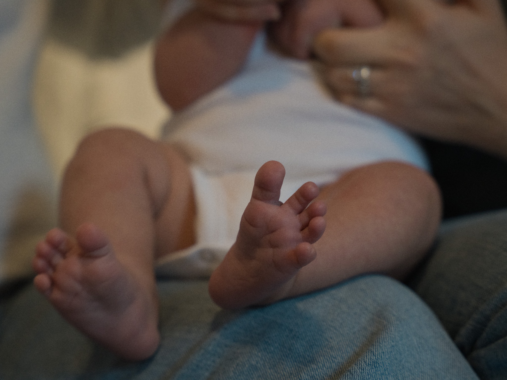 A close detail of a baby's feet while being held